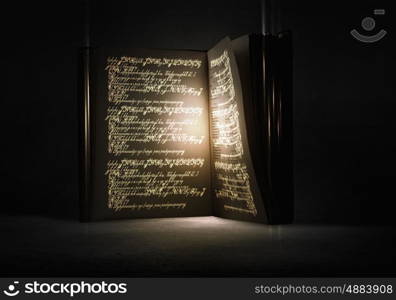 Magic book. Old black magic book with lights on pages