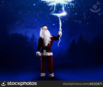 Magic Christmas eve. Santa Clause in red costume against blue background