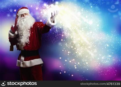 Magic Christmas eve. Santa Clause with gift bag behind shoulders