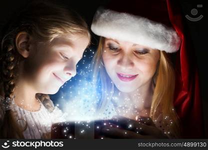 Magic Christmas. Happy mother and daughter opening Christmas gift