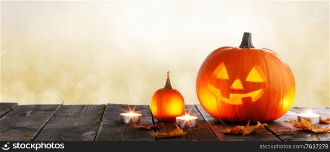 Magic halloween pumpkins and burning candles on golden bokeh lights background. Magic halloween pumpkins