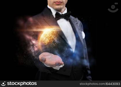 magic, imagination and people concept - male magician with planet and space hologram. male magician with planet and space hologram