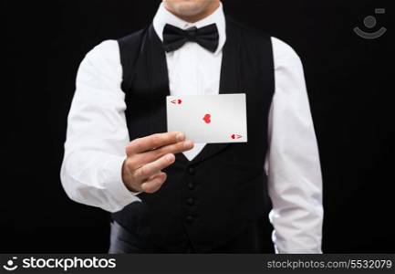 magic, performance, circus, casino and show concept - casino dealer holding white card