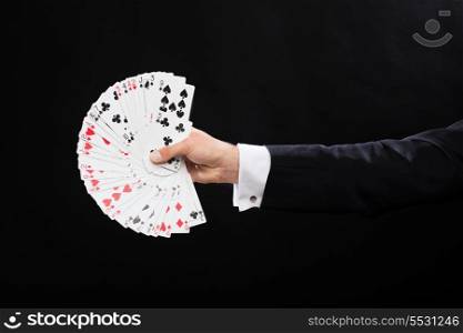 magic, performance, circus, gambling, casino, poker, show concept - close up of magician hand holding playing cards