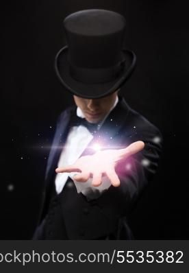 magic, performance, circus, show and advertisement concept - magician holding something on palm of his hand