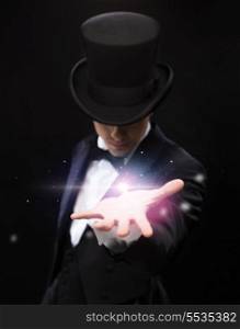 magic, performance, circus, show and advertisement concept - magician holding something on palm of his hand