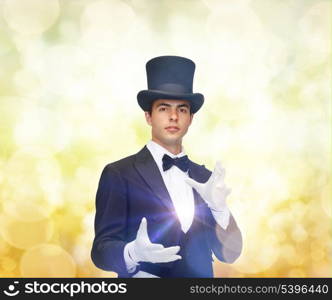 magic, performance, circus, show concept - magician in top hat showing trick