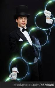 magic, performance, circus, show concept - magician in top hat showing trick with linking rings