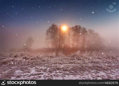 Magic winter Christmas night. Snowfall scene on a river. Frost and snowflakes under the moonlight