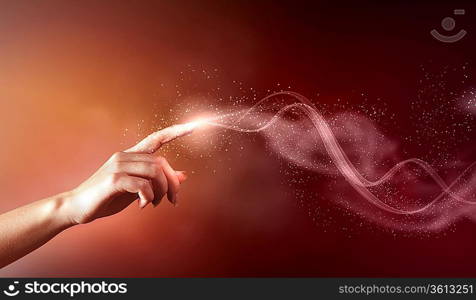 magical hand conceptual image with sparkles on colour background