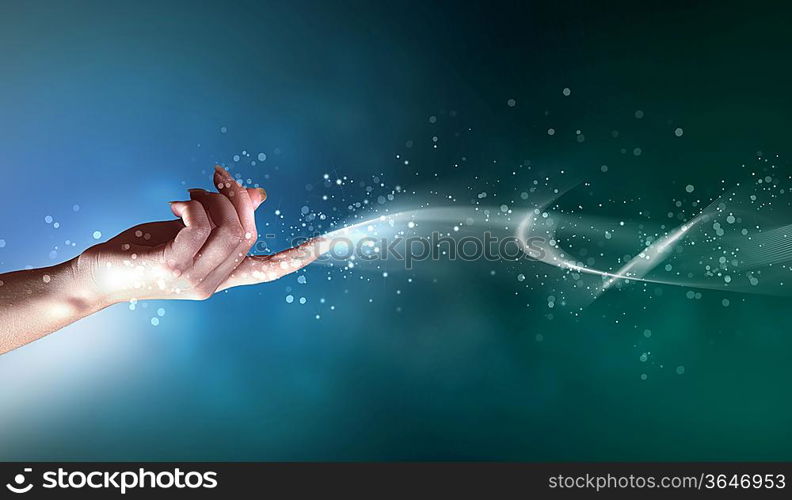 magical hand conceptual image with sparkles on colour background