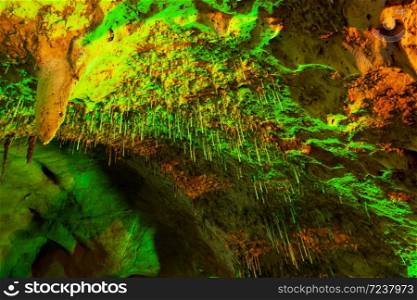 Magical inside of the ancient limestone cave, fantastic green stalagmite glowing in lights. Khao Bin Cave, Ratchaburi, Thailand. Low angle view.