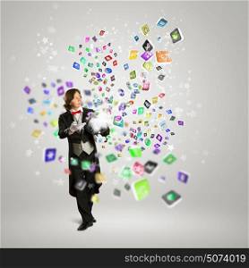 Magician and computer devices. Image of magician with hat and media icons flying in air