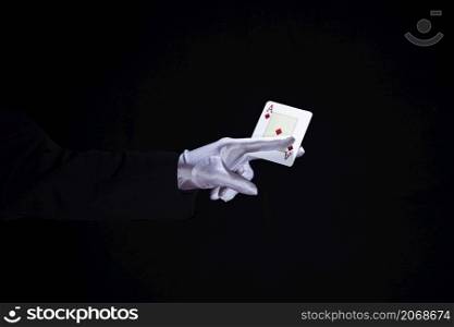 magician holding aces playing card fingers against black background
