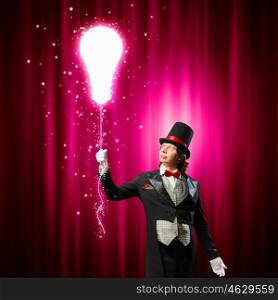 Magician in hat. Image of man magician showing trick against color background