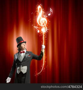 Magician in hat. Image of man magician showing trick against color background