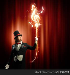 Magician in hat. Image of man magician showing trick against color background