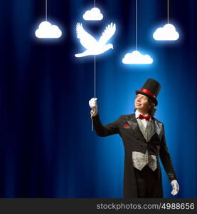 Magician in hat. Image of man magician showing trick against color background