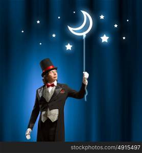 Magician in hat. Image of man magician with balloon against color background