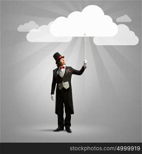 Magician in hat. Image of wizard in hat catching clouds