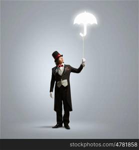Magician in hat. Image of wizard in hat holding umbrella