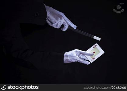magician performing trick aces playing card against black background