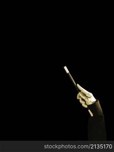 magician s hand holding magic wand against black background
