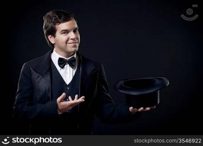 magician showing tricks with top hat isolated on dark background