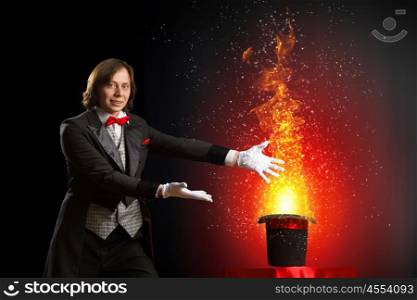 Magician with hat. Image of magician holding hat with lights and fumes going out