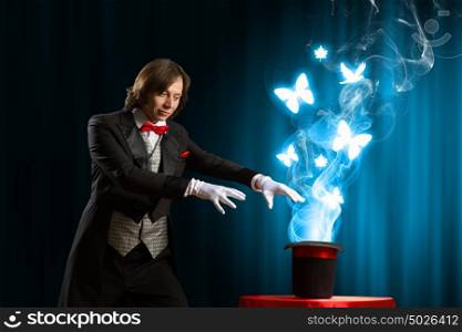 Magician with hat. Image of magician showing tricks with magic hat