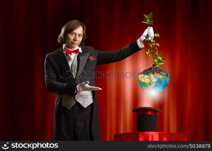 Magician with hat. Image of wizard showing tricks with his hat. Ecology concept. Elements of this image are furnished by NASA