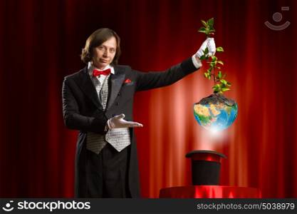 Magician with hat. Image of wizard showing tricks with his hat. Ecology concept. Elements of this image are furnished by NASA