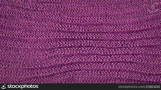 Magneta knitted background with copy space. Fabric purple lavender colored colored texture for background and design.. Beautiful knitted purple plum colored wool textiles as a background