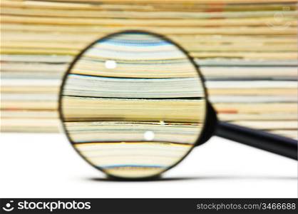 magnifier on the background of the stack of magazines