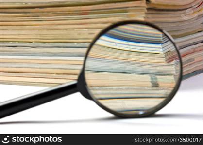 magnifier on the background of the stack of magazines