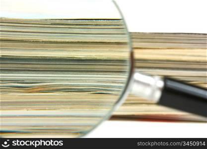 magnifying glass and a stack of magazines