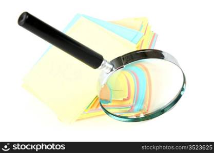 magnifying glass and a stack of paper for notes