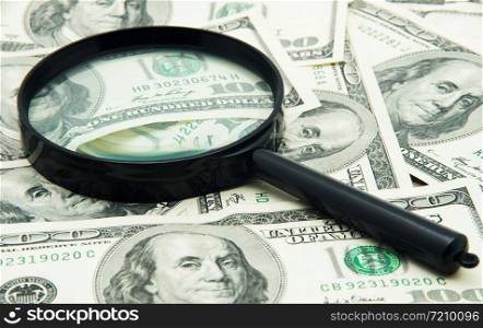 Magnifying glass and money - business background
