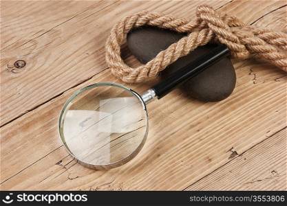 magnifying glass and rope on a wooden background