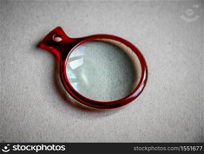 Magnifying glass closeup view on a paper background. Magnifying glass closeup view