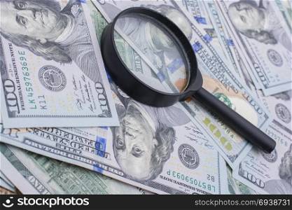 Magnifying glass is placed over of US dollar the banknotes