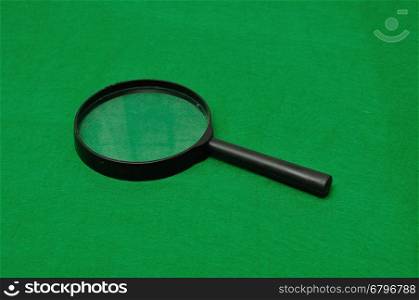 Magnifying glass isolated on a green background