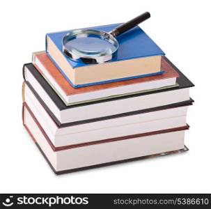 Magnifying glass on stack of books isolated on white