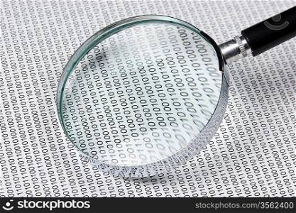 magnifying glass on the background of a binary code