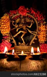 Maha Shivaratri or Diwali concept - Shiva Nataraja figurine with Diwali lights oil ghee candles, India. Shiva Nataraja with Diwali lights