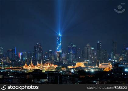 Mahanakhon lights up with Temple of the Emerald Buddha, Grand palace, Wat Pho, and skyscraper buildings. Bangkok City in downtown area at night, Thailand. Buddhist temple.