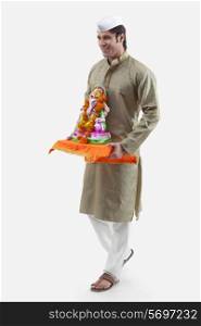 Maharashtrian man holding a Ganesh idol