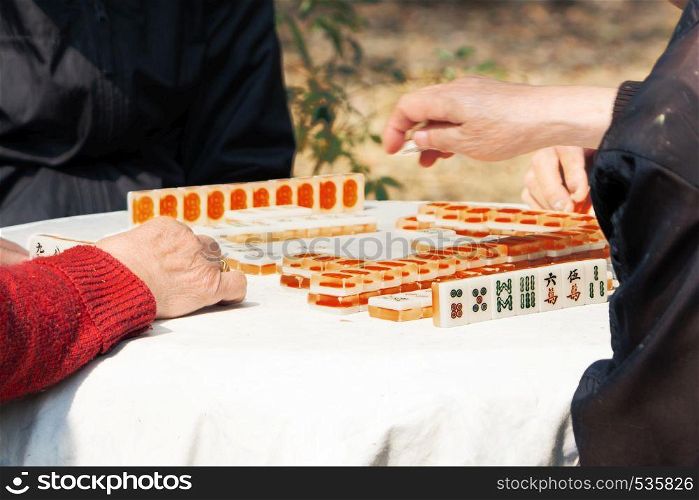 Mahjong table gambling game of Chinese senior on city street