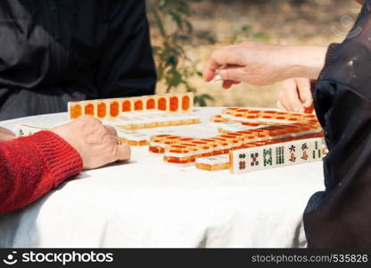 Mahjong table gambling game of Chinese senior on city street