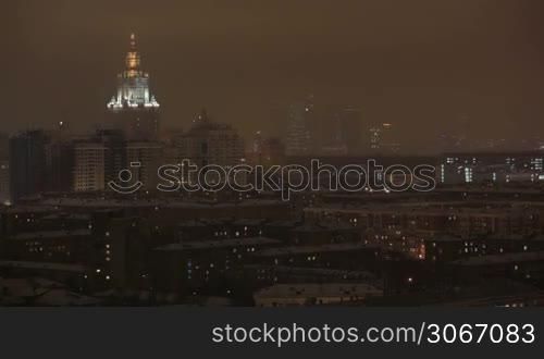 Main building of Moscow State University at night winter in Moscow, Russia, view through window
